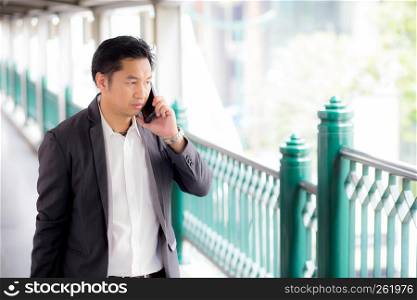 Portrait of a confident business man talking cell phone call outdoor.
