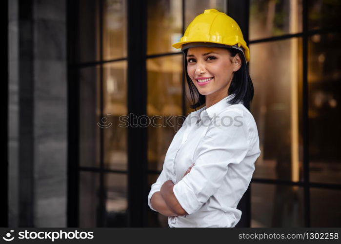 Portrait of a Confident Construction Engineer Woman. Smiling and Looking at Camera. Standing in front of the Modern Office Building