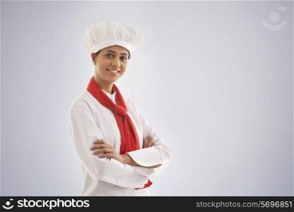 Portrait of a confident female chef isolated over gray background