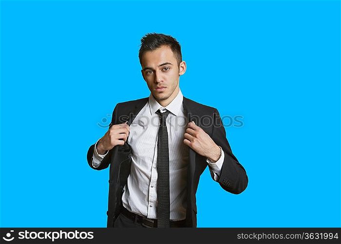 Portrait of a confident young businessman over colored background