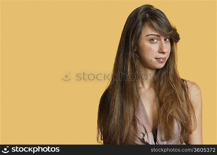 Portrait of a confident young woman over colored background