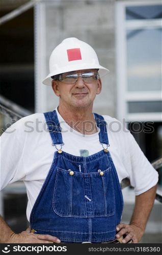 Portrait of a construction worker standing with arms akimbo