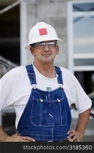 Portrait of a construction worker standing with arms akimbo
