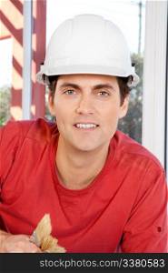Portrait of a construction worker with paint brushes and white hard hat
