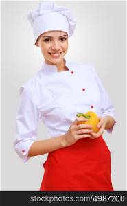 Portrait of a cook. Young female chef in red apron against grey background
