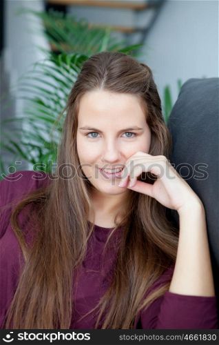 Portrait of a cool woman with long hair smiling. Plants of background