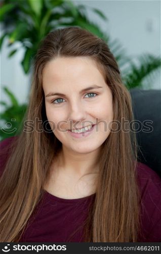 Portrait of a cool woman with long hair smiling. Plants of background