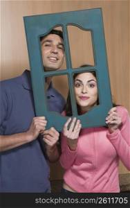 Portrait of a couple holding a window frame