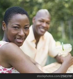 Portrait of a couple holding glasses of cocktail and smiling