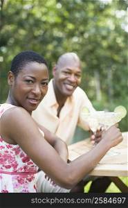 Portrait of a couple holding glasses of cocktail and smiling