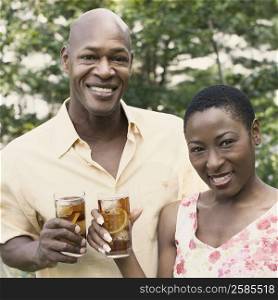 Portrait of a couple holding glasses of ice tea and smiling
