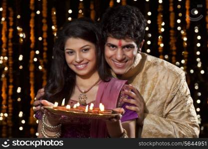 Portrait of a couple with a tray of diyas