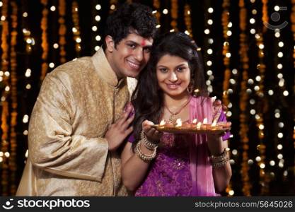 Portrait of a couple with a tray of diyas