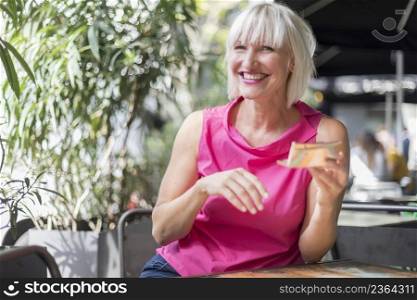 Portrait of a cute blonde smiling woman sitting in a cafe outdoor