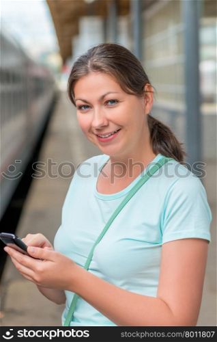 Portrait of a cute girl on a trip near the train
