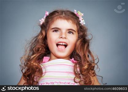 Portrait of a cute happy birthday baby girl, beautiful child playing and making faces, shoot over sky background