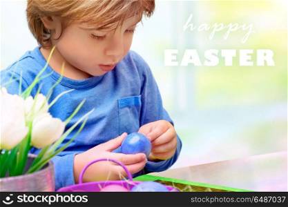 Portrait of a cute little boy painting on the Easter egg, adorable preschooler spending time at home and preparing to great religious holiday, making traditional Easter decorations. Little boy decorating Easter eggs