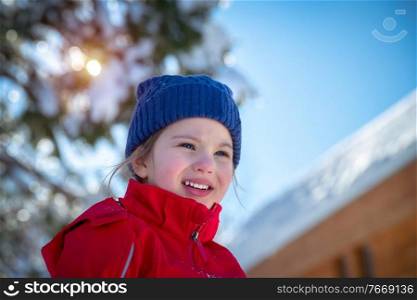 Portrait of a cute little girl having fun outdoors, cheerful child enjoying sunny winter day, happy winter holidays
