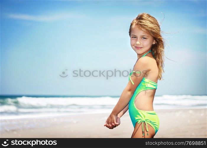 Portrait of a cute little girl on a beach, spending vacation in a summer c&on a seashore, happy healthy childhood