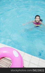 Portrait of a cute little girl swimming in the pool