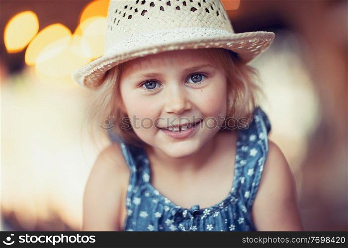 Portrait of a cute little girl wearing stylish straw hat, precious adorable child, happy healthy childhood