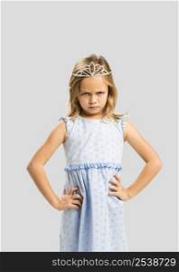 Portrait of a cute little girl with a princess crown making a sad face