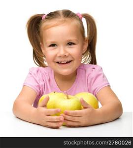 Portrait of a cute little girl with three yellow apples, isolated over white