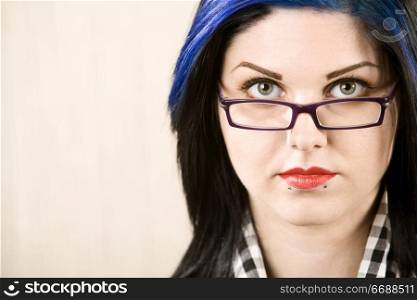 Portrait of a cute rockabilly woman looking over her glasses