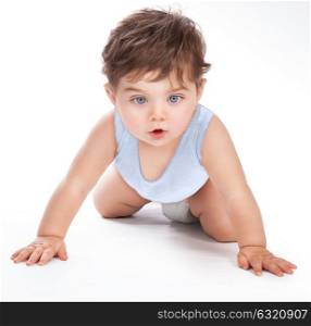 Portrait of a cute sweet baby crawling in the studio, pretty boy isolated on grey white background, little child want to discover everything