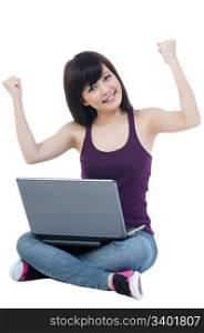 Portrait of a cute young woman sitting on floor with laptop and arms raised over white background.