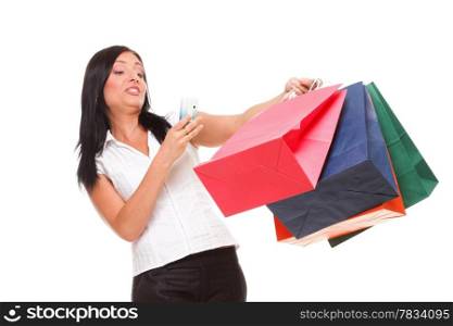 portrait of a cute young woman speaking on the mobile while holding shopping bags against white background