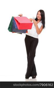 portrait of a cute young woman speaking on the mobile while holding shopping bags against white background