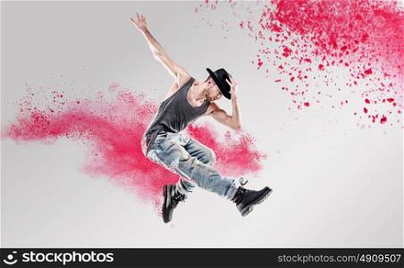 Portrait of a dancer excercising among a colorful powder