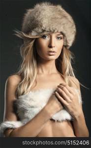 Portrait of a delicate blond woman wearing mink fur hat
