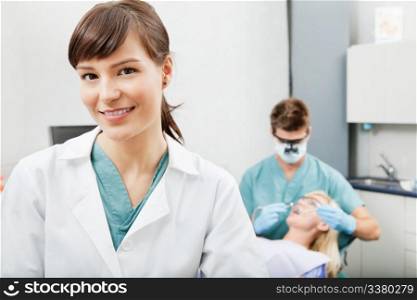 Portrait of a dental assistant smiling with dentistry work in the background. Dental assistant smiling with dentistry work in the background