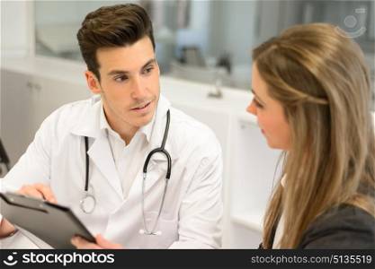 Portrait of a doctor listening to patient explaining her painful in his office