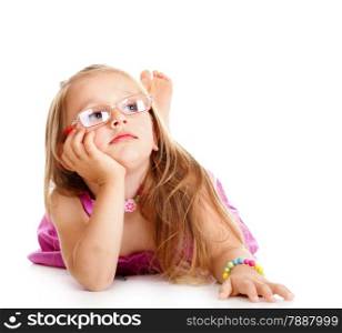 Portrait of a dreaming little girl in glasses laying on floor, isolated over white