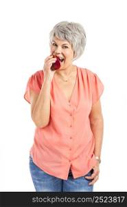 Portrait of a elderly woman eating a red apple