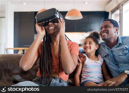 Portrait of a family having fun together and playing video games with VR glasses while staying home. New normal lifestye concept. Stay home.