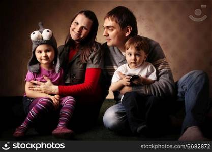 portrait of a family of four, mom dad daughter and son, with young children