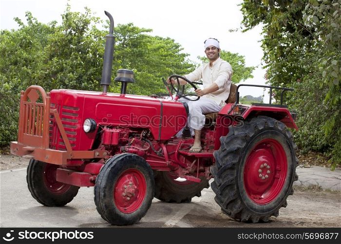 Portrait of a farmer sitting on a tractor smiling