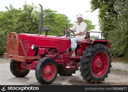Portrait of a farmer sitting on a tractor smiling