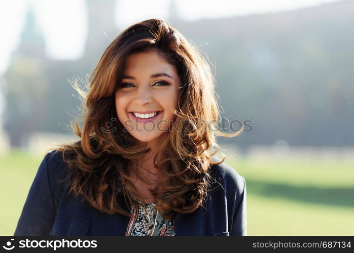 Portrait of a fashionable and lovely woman with nice hairstyle posing outdoor on a sunny day