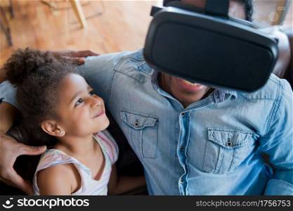 Portrait of a father and daughter playing video games with VR glasses while staying home. Monoparental concept. Stay home concept.