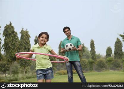 Portrait of a father and his daughter playing outdoors