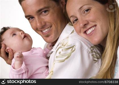 Portrait of a father holding his son and smiling with his wife