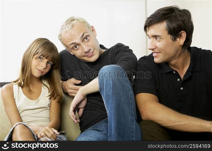 Portrait of a father with his daughter and a young man sitting beside them