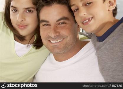 Portrait of a father with his son and his daughter smiling