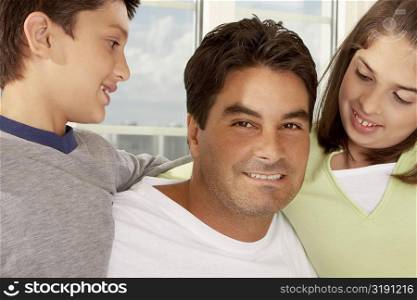 Portrait of a father with his son and his daughter smiling