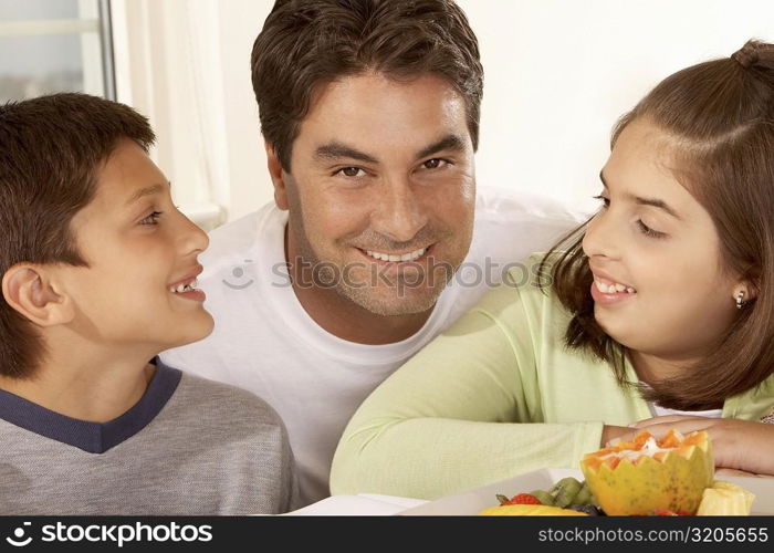 Portrait of a father with his son and his daughter smiling